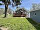 Quaint home with a red front door and a charming wooden deck, surrounded by a well-maintained lawn at 1942 E Edgewood Ave, Indianapolis, IN 46227
