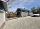 View of the side and back of the house with a rock driveway and partially fenced yard at 1942 E Edgewood Ave, Indianapolis, IN 46227