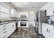 Well-lit kitchen features stainless steel appliances, sleek dark countertops, and white cabinetry at 19510 Pathway Point, Noblesville, IN 46062