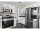 Well-lit kitchen features stainless steel appliances, sleek dark countertops, and white cabinetry at 19510 Pathway Point, Noblesville, IN 46062