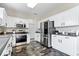 Well-lit kitchen features stainless steel appliances, sleek dark countertops, and white cabinetry at 19510 Pathway Point, Noblesville, IN 46062
