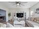 Bright living room showcasing a stylish entertainment center, ceiling fan, and neutral-toned decor at 19510 Pathway Point, Noblesville, IN 46062