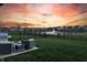 Outdoor seating area with grill overlooking a serene pond and fountain at sunset at 20515 Quicksilver Rd, Noblesville, IN 46062