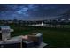 Cozy outdoor seating area with grill overlooking a serene pond and fountain at dusk at 20515 Quicksilver Rd, Noblesville, IN 46062
