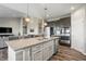 Spacious kitchen island with granite countertops, stainless steel appliances, and seating that opens to the living room at 20515 Quicksilver Rd, Noblesville, IN 46062