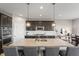 Stylish kitchen featuring a large island with bar stools, granite countertops, pendant lighting, and dark cabinets at 20515 Quicksilver Rd, Noblesville, IN 46062