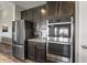 Kitchen detail showcases stainless steel appliances, granite countertops, and dark wood cabinets for a modern, sleek design at 20515 Quicksilver Rd, Noblesville, IN 46062