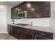 Close-up of a kitchen featuring dark cabinets, granite countertops, stainless steel appliances, and a white tile backsplash at 20515 Quicksilver Rd, Noblesville, IN 46062