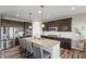 Modern kitchen with dark cabinetry, granite countertops, stainless steel appliances, and a large island with bar seating at 20515 Quicksilver Rd, Noblesville, IN 46062