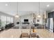 Kitchen island with granite counters, stainless steel appliances, seating, and an open view to the living area with fireplace at 20515 Quicksilver Rd, Noblesville, IN 46062