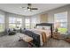 Spacious main bedroom with a stylish bed, a ceiling fan, two side tables, and lots of natural light at 20515 Quicksilver Rd, Noblesville, IN 46062