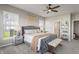 Bright main bedroom with a stylish grey bed, a ceiling fan, and a bench at the foot of the bed at 20515 Quicksilver Rd, Noblesville, IN 46062