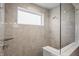 Shower with beige tile, a glass door, a window, and a shower head at 20515 Quicksilver Rd, Noblesville, IN 46062