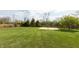 Expansive backyard with lush green grass, mature trees, and a basketball court, perfect for outdoor activities at 2093 Autumn Faith Way, Avon, IN 46123