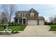 Traditional two-story home with brick facade, three-car garage, and manicured lawn at 2093 Autumn Faith Way, Avon, IN 46123