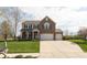 Beautiful two-story brick home featuring a manicured lawn and a long driveway leading to a spacious three-car garage at 2093 Autumn Faith Way, Avon, IN 46123