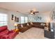 Spacious living room featuring a large sectional sofa, ceiling fan, and natural light from the window at 2093 Autumn Faith Way, Avon, IN 46123