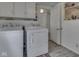 Functional laundry room featuring a washer and dryer, wall cabinets, and vinyl flooring at 213 N Walnut St, Edinburgh, IN 46124