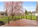 View of a stained deck overlooking a fenced yard with a blossoming tree and shed, great for outdoor enjoyment at 217 Eikenberry St, Greenfield, IN 46140