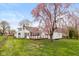 Large backyard with a deck and lush tree featuring pink blossoms at 217 Eikenberry St, Greenfield, IN 46140
