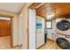 Well-lit laundry room with modern washer and dryer, accented by natural wood trim and an adjacent doorway at 218 Miami Dr, Noblesville, IN 46062