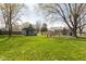 Large, green backyard featuring a guest house, main house, and mature trees at 218 Miami Dr, Noblesville, IN 46062