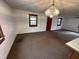 Open living room with vintage chandelier, neutral carpeting, and natural light streaming through the windows at 2975 High Rock Dr, Martinsville, IN 46151