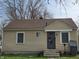 Cozy single-story home with tan siding, a brown roof, and a secure front door at 3101 N Temple Ave, Indianapolis, IN 46218