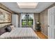 This bedroom features a cozy bed, wood-paneled walls, and a bright window for natural light at 3155 W 57Th St, Indianapolis, IN 46228