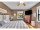 Inviting bedroom features a comfortable queen bed, wood floors, ample natural light, and a TV on the dresser at 3155 W 57Th St, Indianapolis, IN 46228