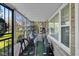 Sunroom converted into an exercise room with various cardio machines and outdoor views at 3155 W 57Th St, Indianapolis, IN 46228