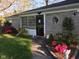A charming home featuring a well-manicured lawn, mature trees, and a welcoming front entrance with colorful flowers at 3155 W 57Th St, Indianapolis, IN 46228