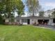 Charming ranch-style home featuring a well-manicured lawn and an attached garage overflowing with possessions at 3155 W 57Th St, Indianapolis, IN 46228