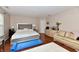 Main bedroom showcasing hardwood floors, a decorative bed, and sitting area with sofa at 3316 Gainesville Ct, Indianapolis, IN 46227