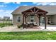 Beautifully landscaped backyard featuring a covered seating area for outdoor entertaining at 3572 Westmore Cir, Bargersville, IN 46106