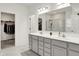 Bright bathroom featuring double vanity with gray cabinetry and white countertop, with walk-in closet and tiled shower at 3572 Westmore Cir, Bargersville, IN 46106