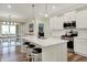 Kitchen features white cabinets, quartz countertops, stainless appliances, and an island with seating, open to the dining room at 3572 Westmore Cir, Bargersville, IN 46106