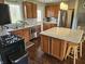 Spacious kitchen with stainless steel appliances, wooden cabinets, granite countertops, an island, and a breakfast bar at 366 E 200 N, Franklin, IN 46131