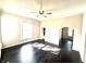 Sun-filled living room with dark wood floors, white trim, and a ceiling fan at 404 W Green St, Lebanon, IN 46052