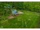 Expansive backyard featuring lush greenery, a gravel area, and a quaint outbuilding, ideal for outdoor activities at 4151 N Pennsylvania St, Indianapolis, IN 46205
