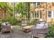 Lush backyard featuring an outdoor seating area with stone pavers, chairs and trees at 4151 N Pennsylvania St, Indianapolis, IN 46205