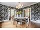 Stylish dining room featuring floral wallpaper, modern lighting, and seamless access to adjacent living spaces at 4151 N Pennsylvania St, Indianapolis, IN 46205