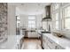 Bright, white kitchen features stainless steel appliances, marble countertops, and a brick accent wall at 4151 N Pennsylvania St, Indianapolis, IN 46205