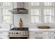 Bright kitchen featuring stainless steel stove and range hood against white subway tile at 4151 N Pennsylvania St, Indianapolis, IN 46205