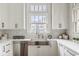A well-lit kitchen featuring stainless steel appliances and bright white cabinetry at 4151 N Pennsylvania St, Indianapolis, IN 46205