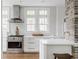 Well-lit kitchen with white cabinets, stainless steel range hood, and expansive windows at 4151 N Pennsylvania St, Indianapolis, IN 46205