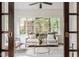Bright sunroom featuring a comfortable sofa, stylish decor, and large windows offering an inviting view at 4151 N Pennsylvania St, Indianapolis, IN 46205