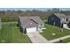 Pleasant home in a suburban area features a well-manicured lawn, a garage, and a paved driveway at 4323 Stubbington Ln, Indianapolis, IN 46239