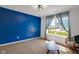 Bright bedroom featuring a bold blue accent wall and modern lighting at 4323 Stubbington Ln, Indianapolis, IN 46239
