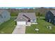 Aerial view of brick single-Gathering home with well-manicured lawn, attached garage, and a red door at 4323 Stubbington Ln, Indianapolis, IN 46239